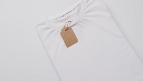 video of white folded t shirt with tag and copy space on white background