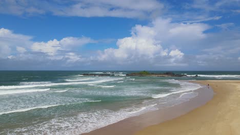 Olas-Moviéndose-Hacia-La-Costa-Arenosa-Contra-El-Cielo-Azul-Con-Nubes-Durante-El-Verano-En-La-Playa-De-Sawtell,-Nueva-Gales-Del-Sur,-Australia