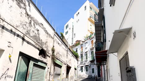 Quiet,-narrow-alley-with-closed-shops-and-graffiti,-daytime---Neapol,-Italy