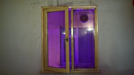 window of an old house with surreal neo light.