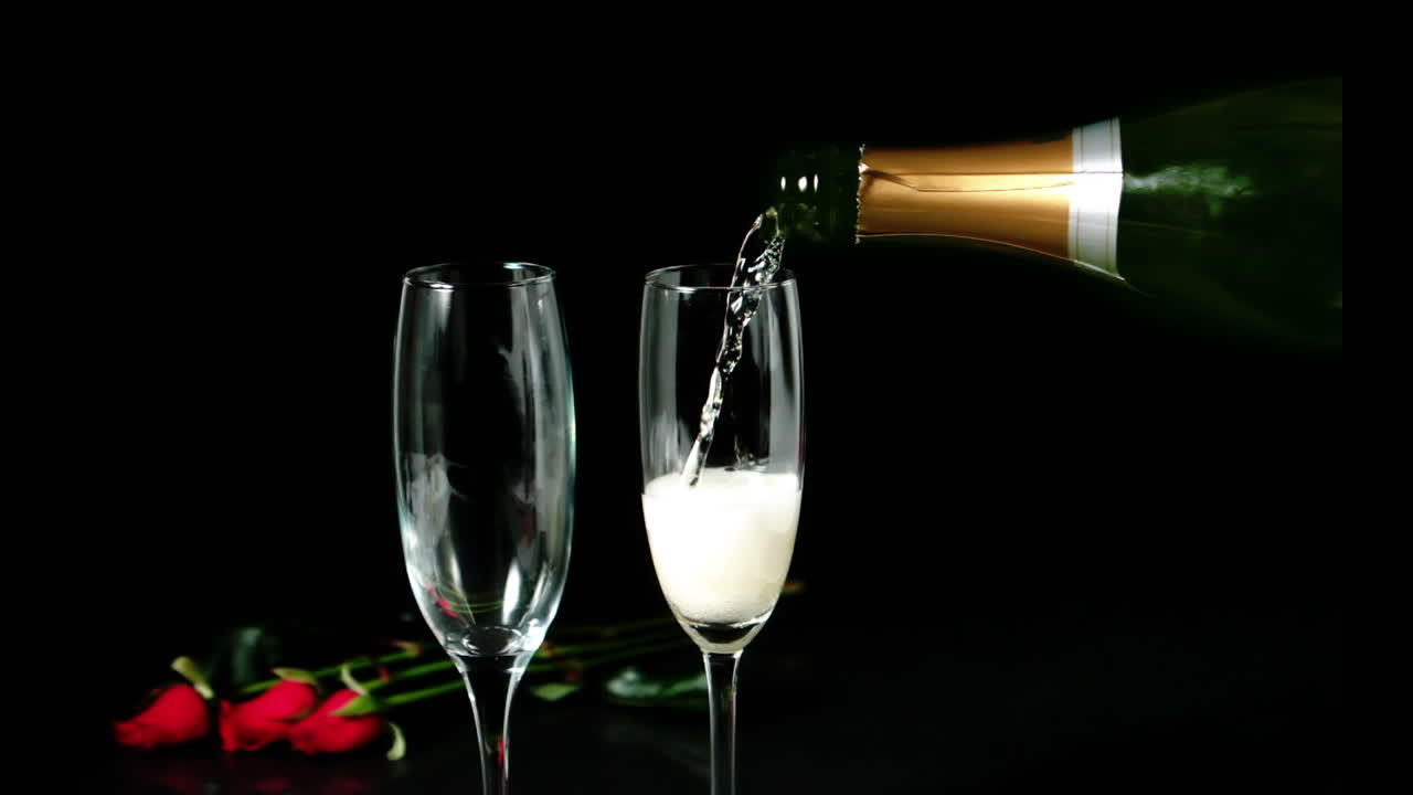 Champagne pouring on a flute with roses behind it 