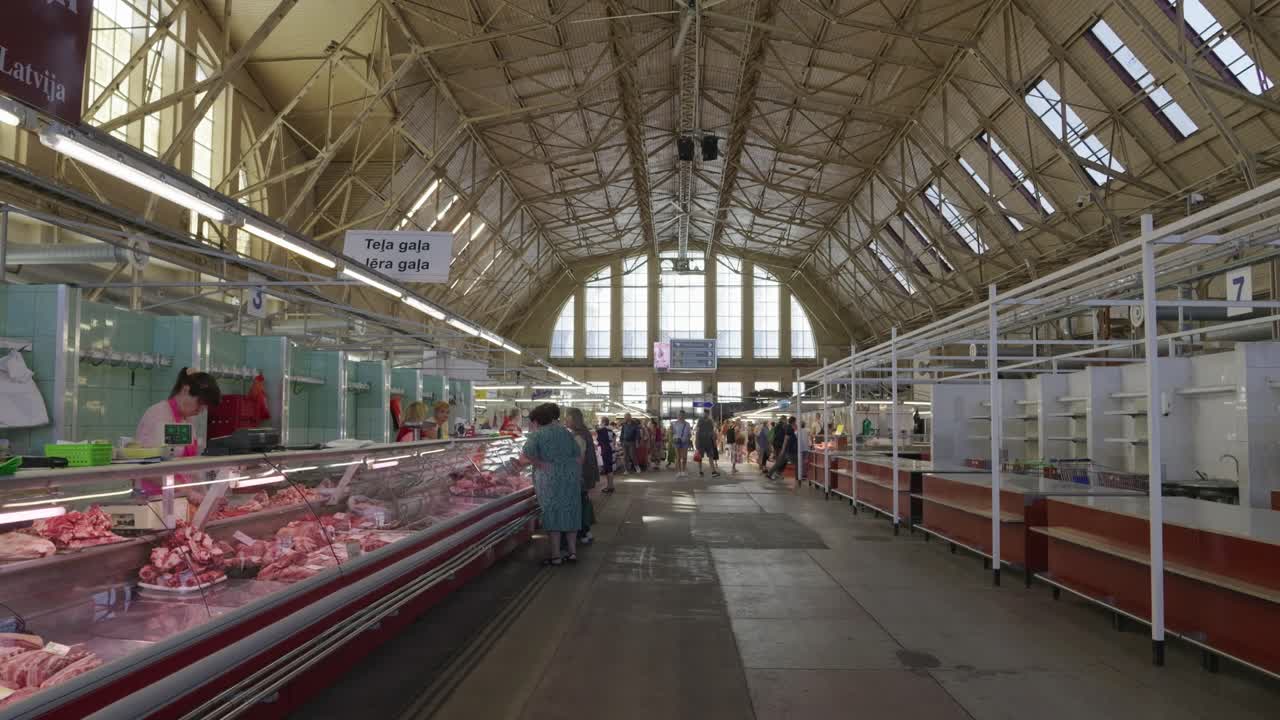 Riga Central Market: A bustling indoor market with fresh meat and people shopping