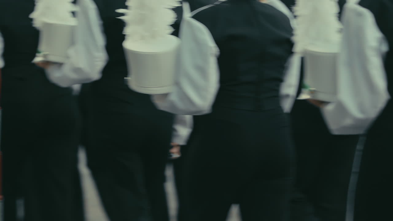 Cinematic high school marching band members walking by in slow motion