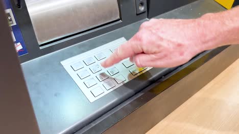 mano interactuando con el teclado del cajero automático