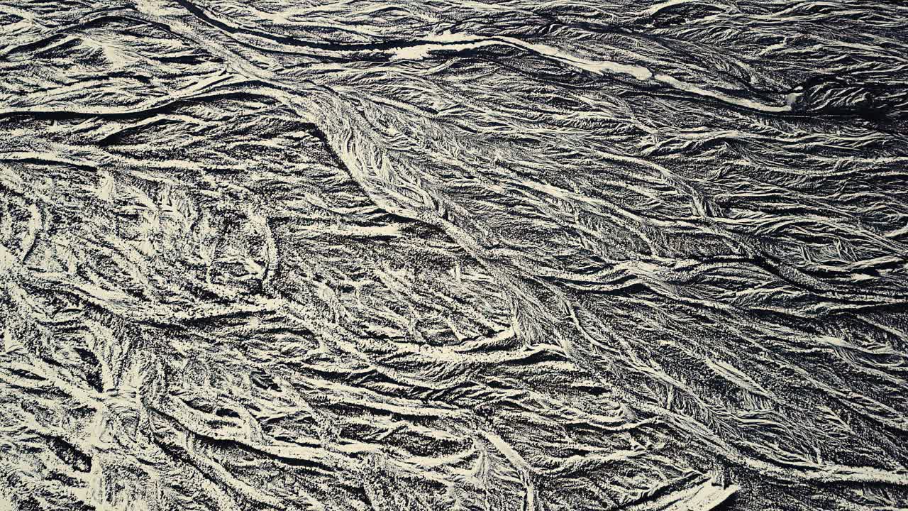 dron que muestra hermosos patrones en el paisaje de abajo, en condiciones de nieve