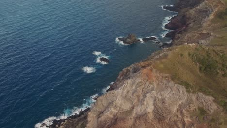 Amplia-Toma-Aérea-De-Una-Costa-Tropical-Rocosa-Con-Olas-Rompiendo-En-La-Base