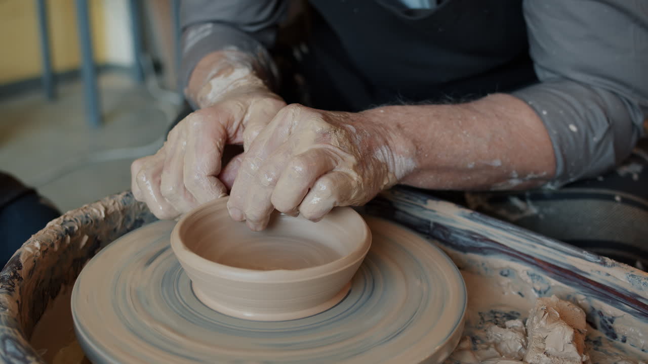 Person Shaping Clay on a Potter's Wheel