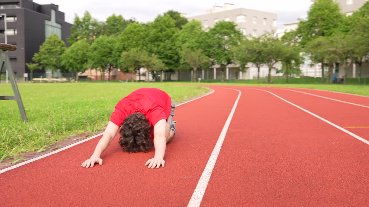 Man Stretching on Running Track