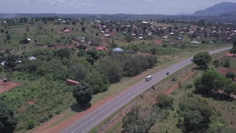 aerial tracks transit bus on highway entering town in malawi, africa