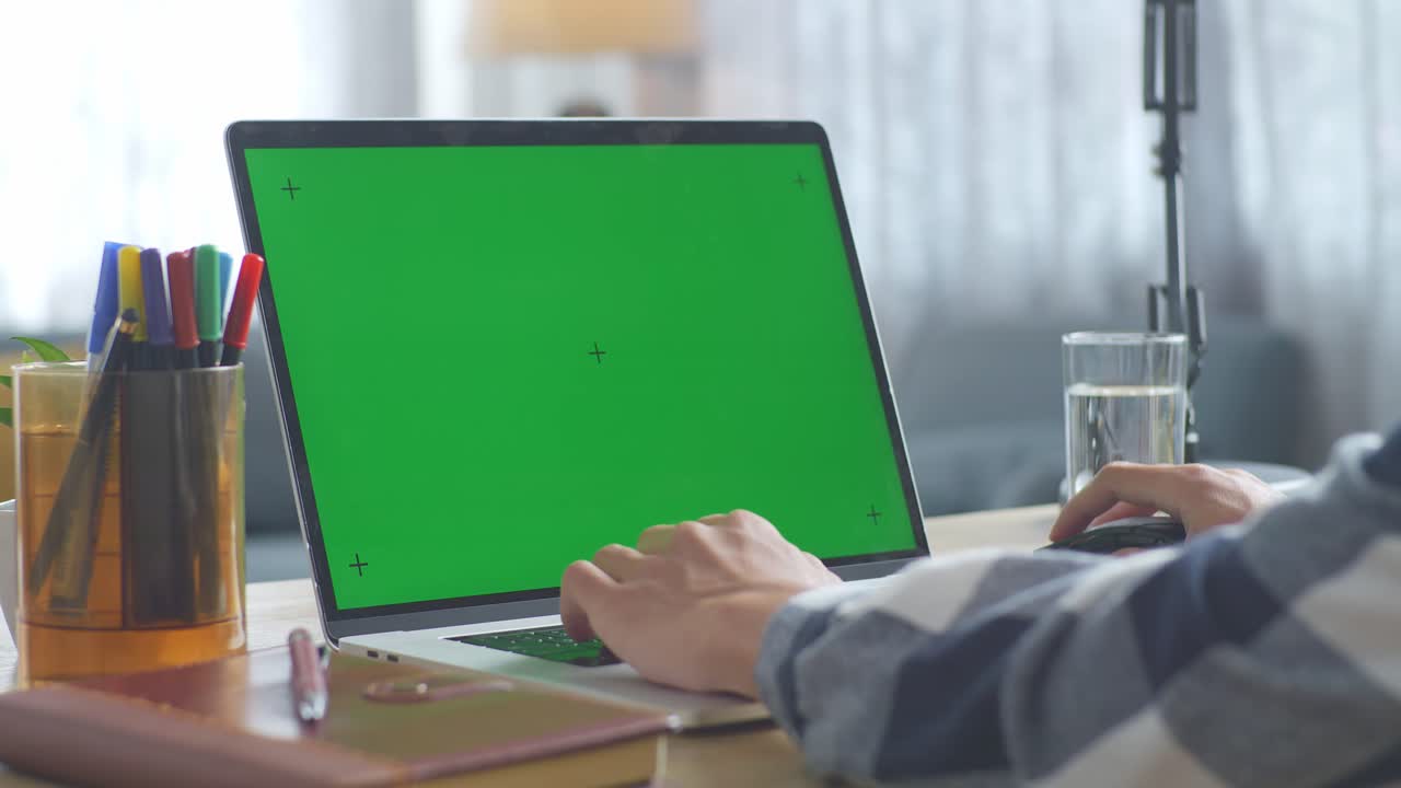 persona trabajando en una computadora portátil con una pantalla verde