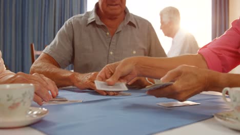 amigos mayores jugando a las cartas