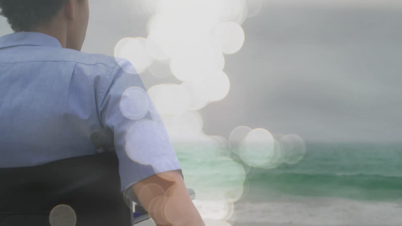 체어에 앉아 있는 장애인 아프리카계 미국인 남성 위에 있는 빛의 반점들의 애니메이션