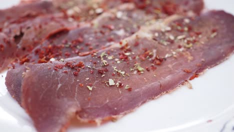 Close up of Turkish pasturma (beef jerky) with red pepper flakes and cumin