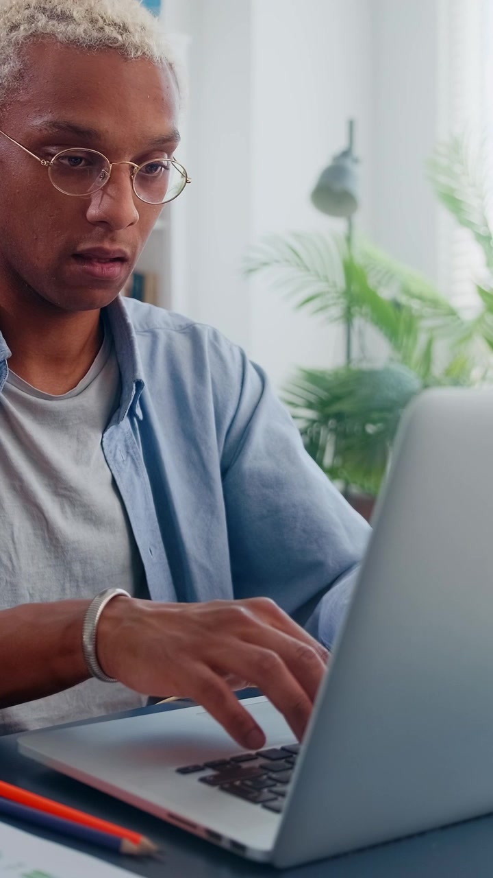 Close up of focused blonde african american man typing on laptop