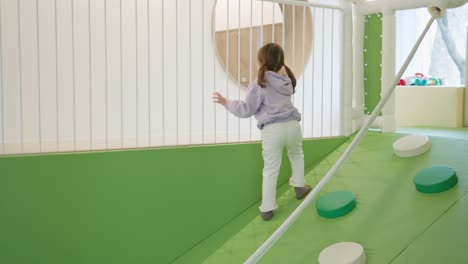 toddler girl playing on indoor playground