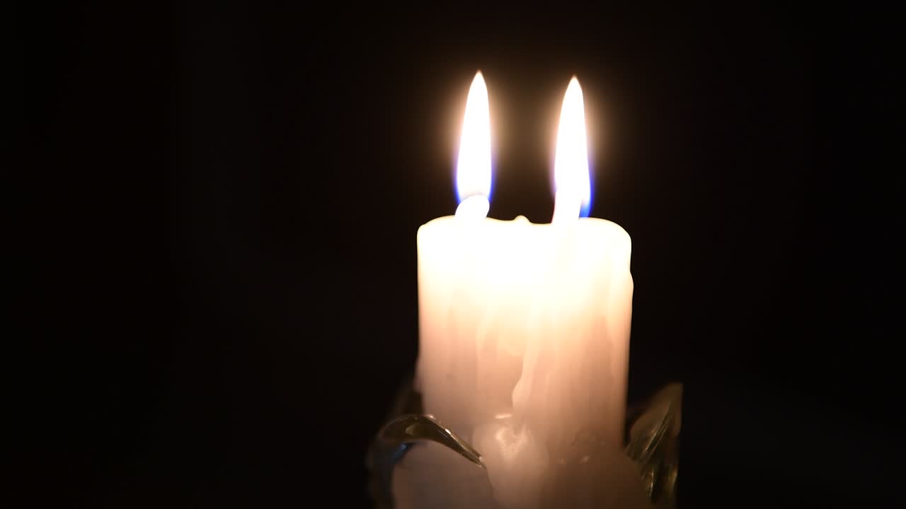 Fiamma infinita di due candele bianche nella notte.