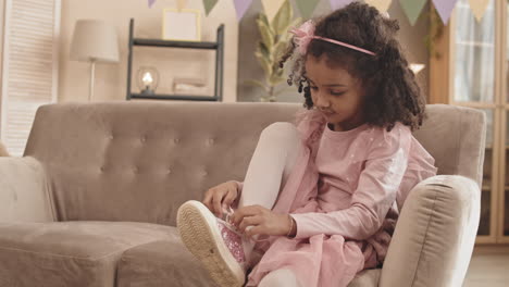 little girl trying lacing shoe
