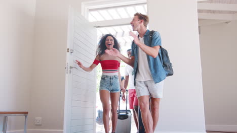 excited group of friends arriving at summer vacation rental