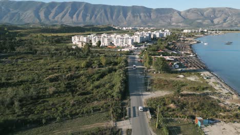 Toma-Aérea-De-Autos-Conduciendo-A-Través-De-La-Ciudad-Albanesa-De-Orikum-Durante-El-Amanecer