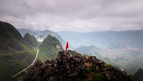 vietnam flag on top of mountain with foggy landscape in background. aerial lateral view