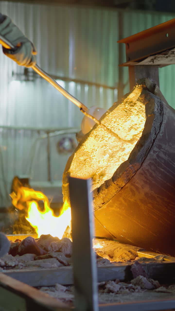 trabajador de la fundición inclinando la cuchara para verter metal fundido con llamas y chispas