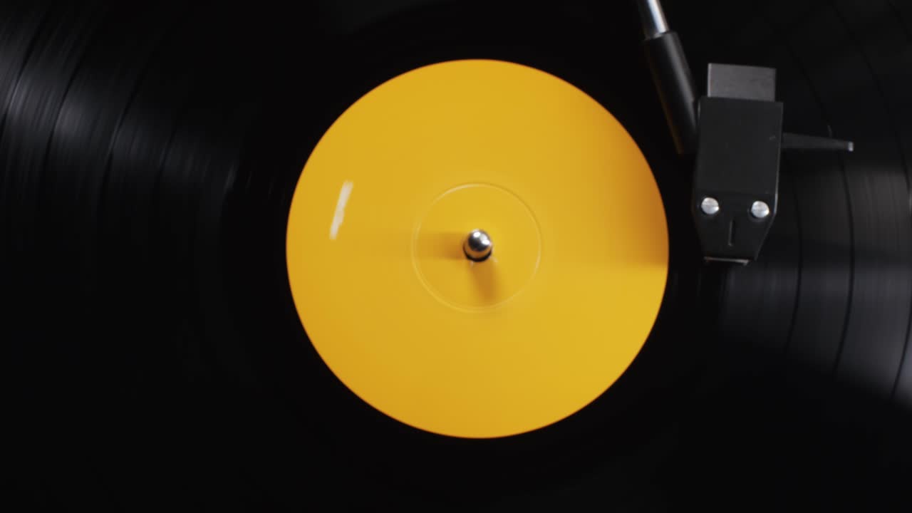 Retro Vinyl record player playing music, close-up macro shot of vintage LP disc old phonograph spinning. Retro music player.