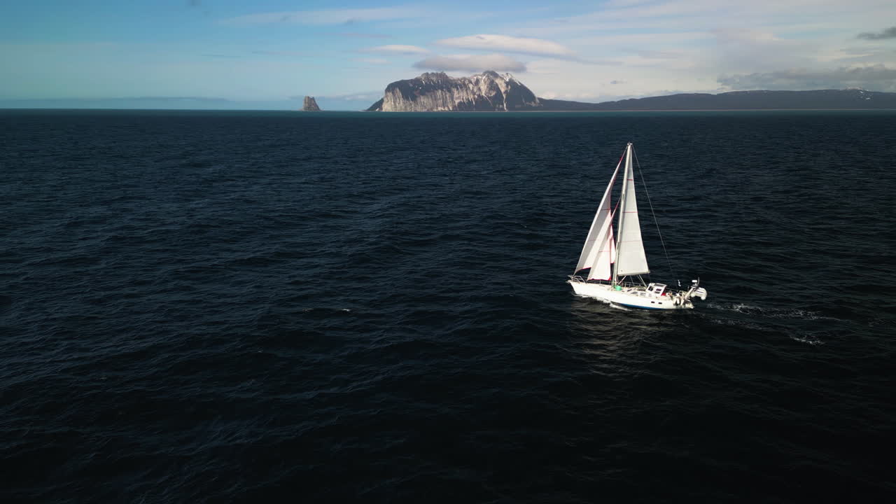 tomada de un avión no tripulado de un velero blanco que atraviesa el soleado golfo de alaska