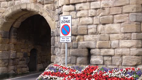 british flag made of flowers by road and gate to alnwick medieval town, england uk