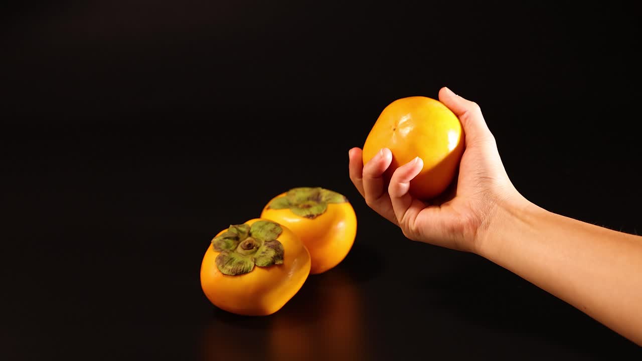 manos interactuando con persimmon en fondo oscuro