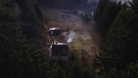 smoke form a house chimney making dense smog in a remote village in the middle of the forest