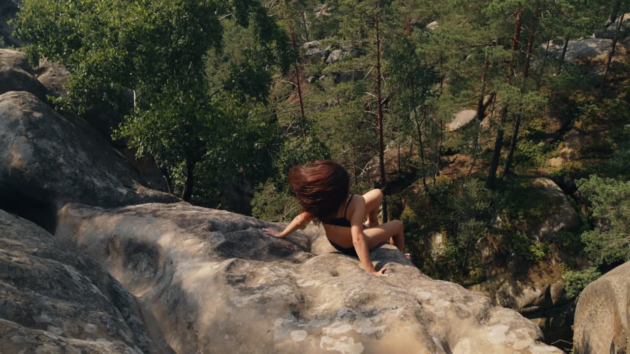 mujer sentada en la cima de la colina mira la vista panorámica de la cordillera amanecer. la dama es peligrosamente