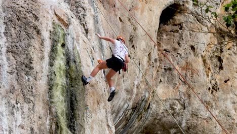 climber scaling limestone cliffs with support team