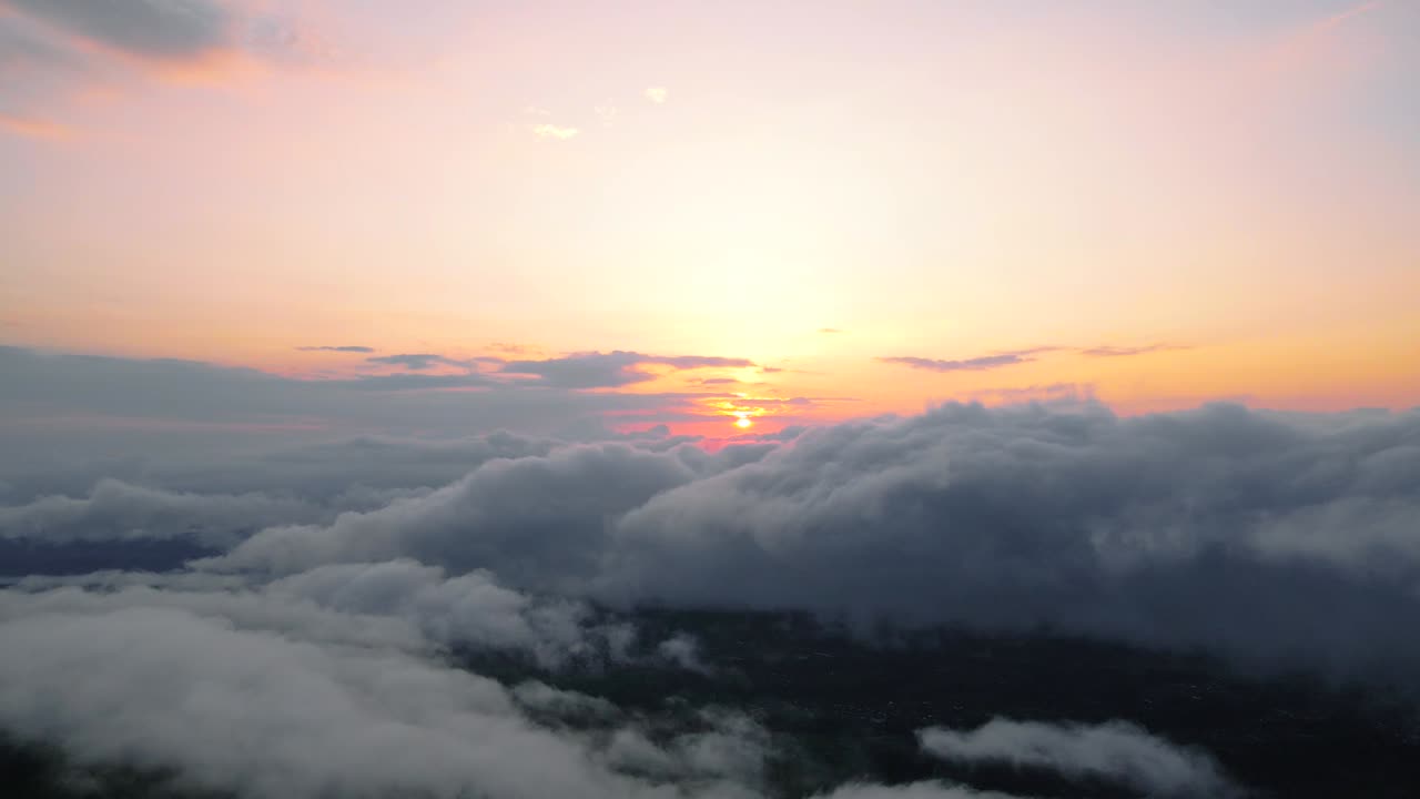 Veduta aerea del sole che sorge sopra le nuvole.