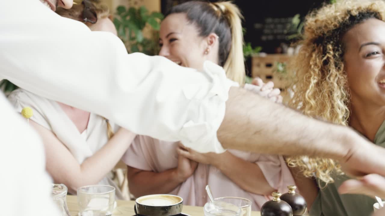 4k video footage of an attractive young woman sitting with her friends in a cafe and showing her ultrasound