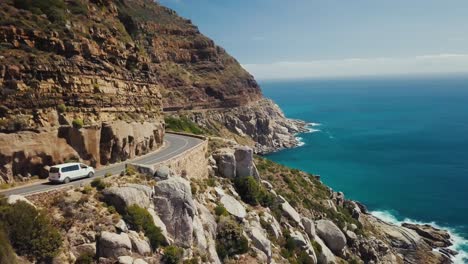 Drone-flying-with-a-white-van-on-a-scenic-coastal-route-in-Cape-Town-South-Africa