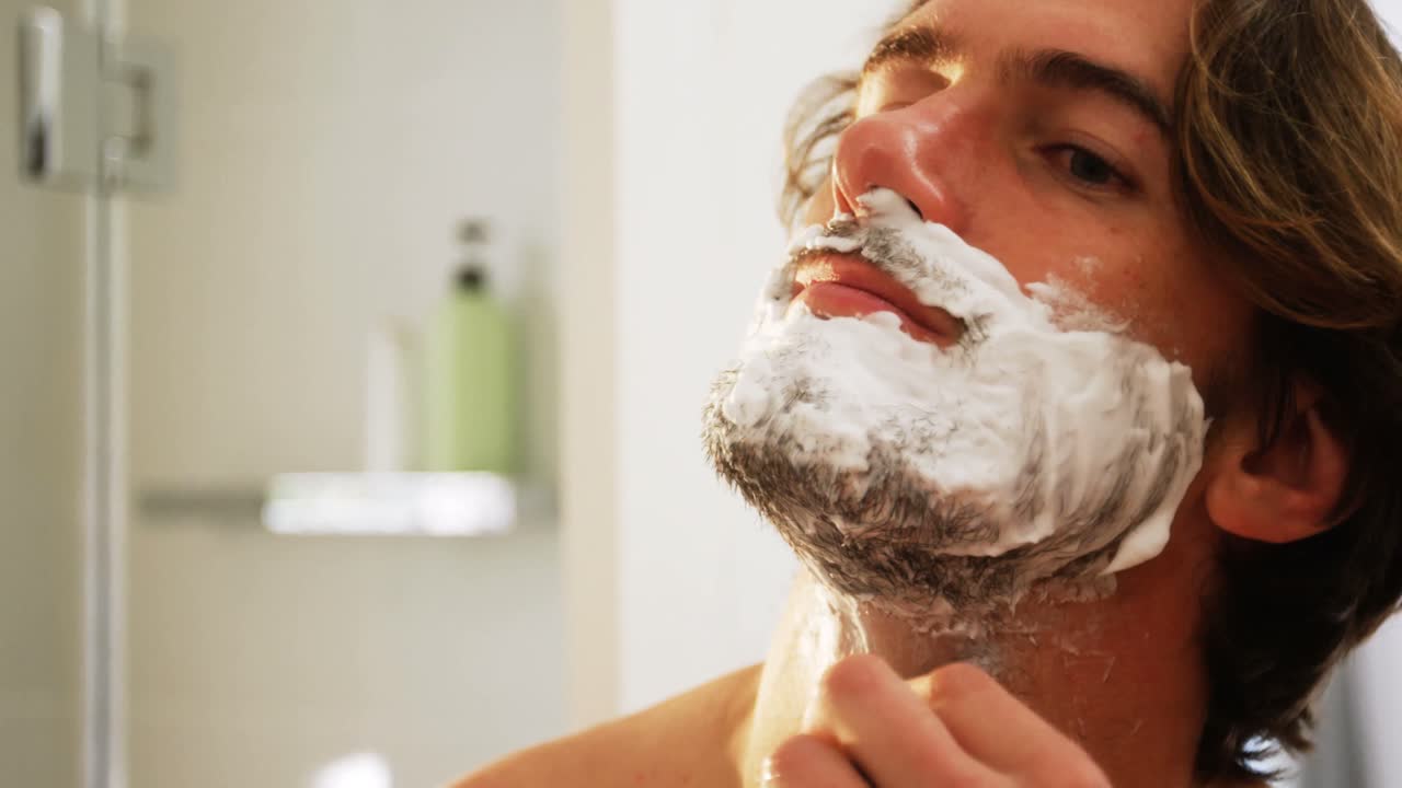 hombre usando una navaja para afeitarse la barba