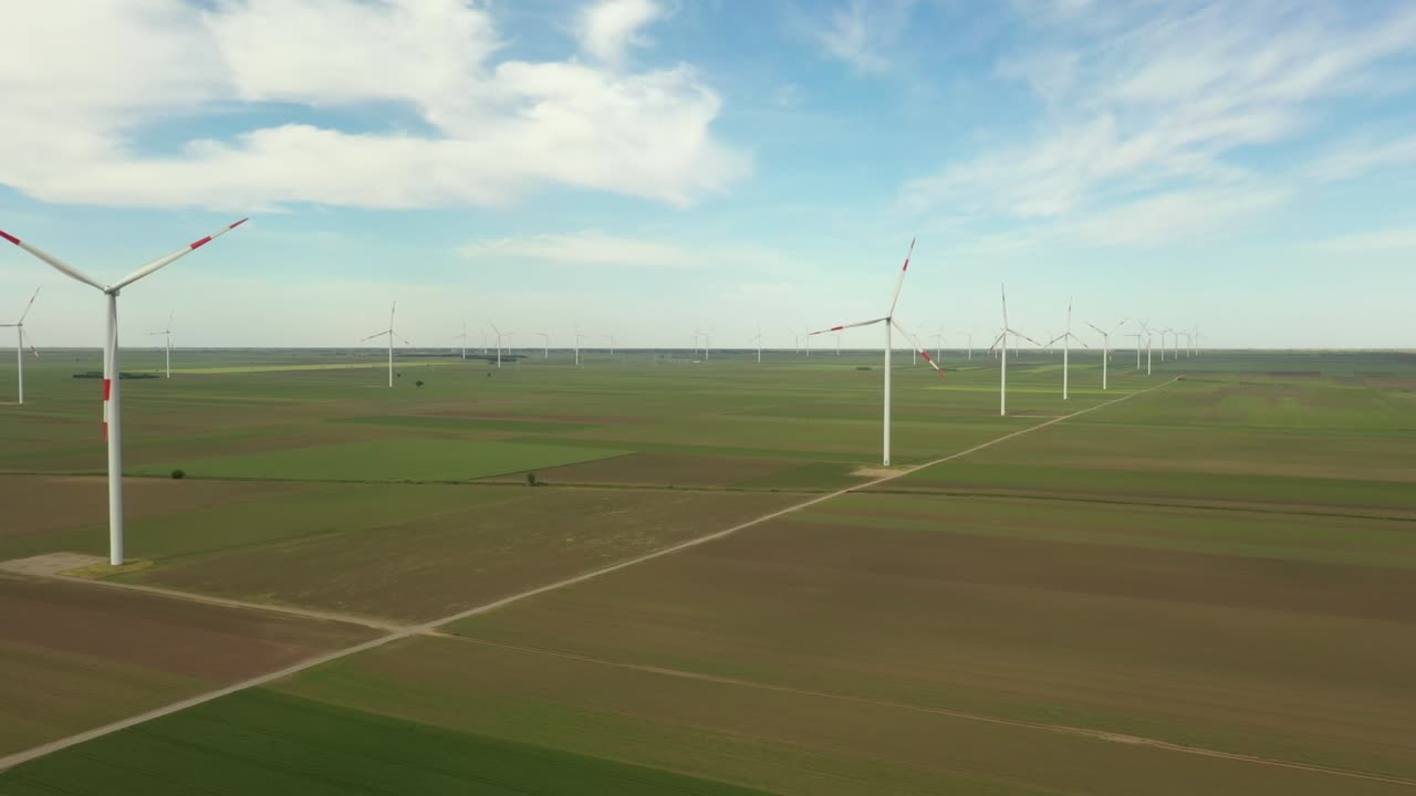 View of several windmills, wind generators, turbines, producing renewable clean energy by converting kinetic energy