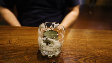 man drinking beer at a wooden table