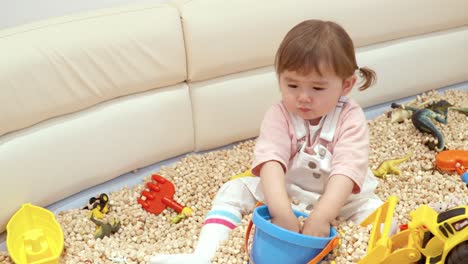 Portrait-Of-A-Two-Years-Old-Toddler-Playing-Toy-Bucket-In-A-Cafe