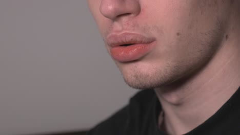 primer plano de un joven vapeando un vaporizador eléctrico - plano medio
