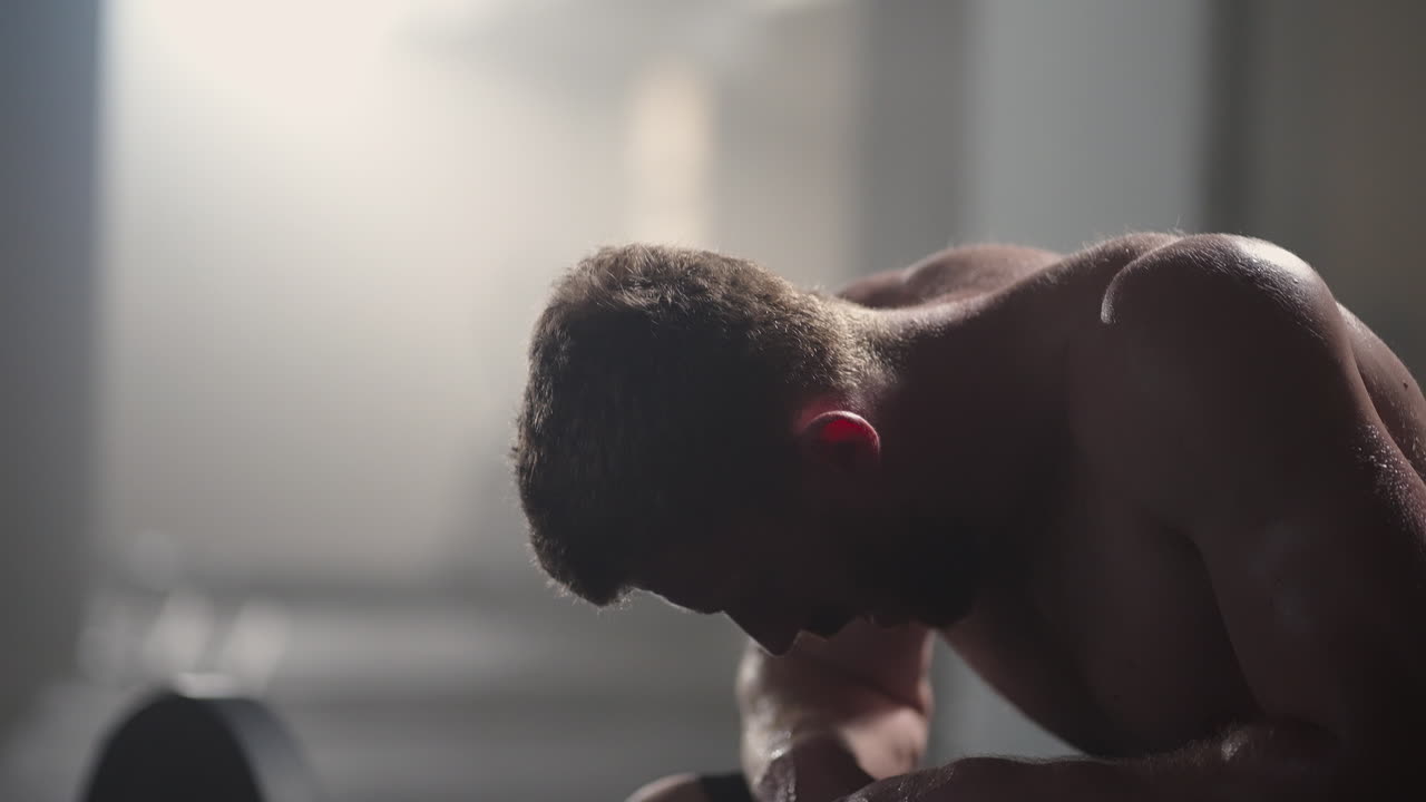 체육관에서 집중적인 운동을 한 후 휴식을 취하는 지친 젊은 남성. 체육관에서 근력 훈련 운동을 한 후 피곤한 건강한 남성. 강렬한 운동을 한 후 서서 휴식을 취하는 피곤한 남성 피트 모델.