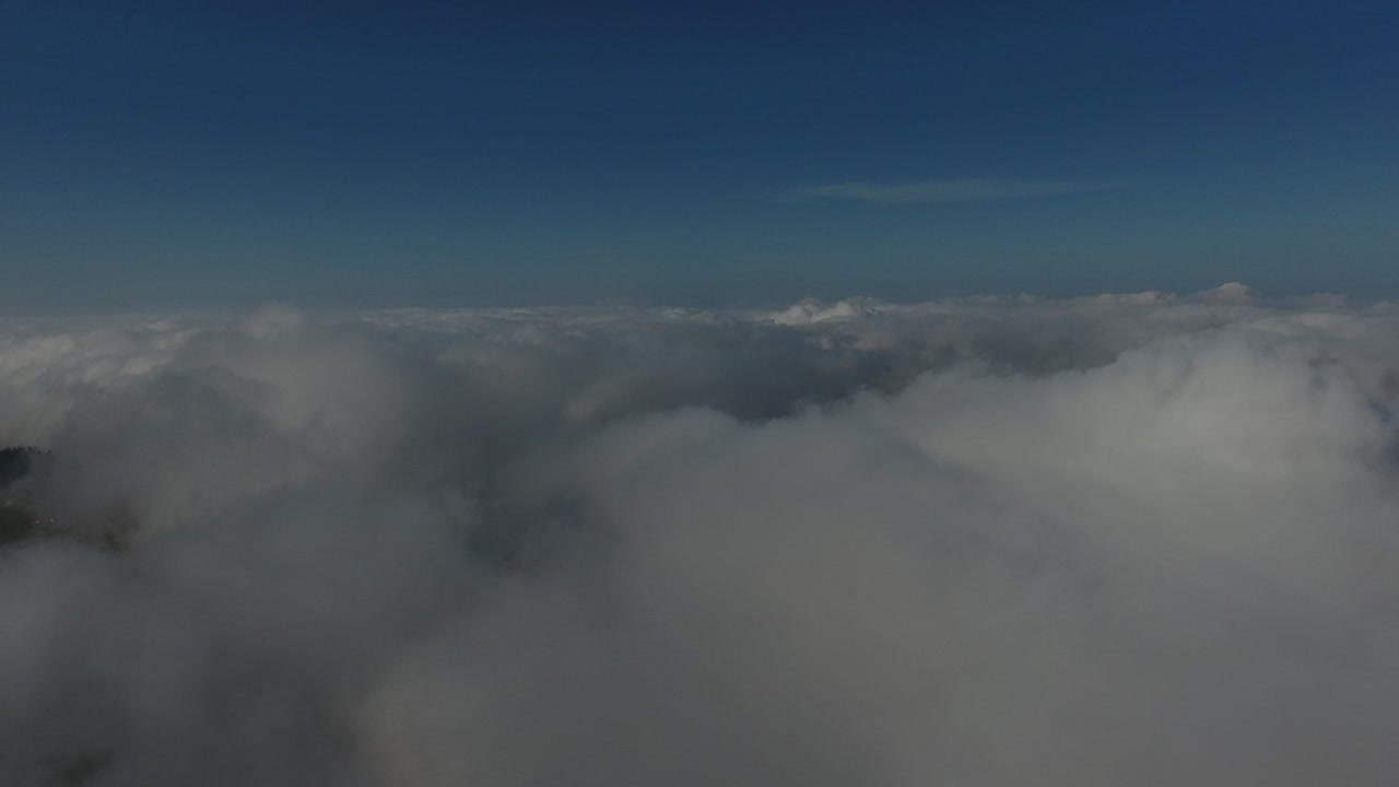 volando sobre las altas montañas en hermosas nubes. vista aérea.