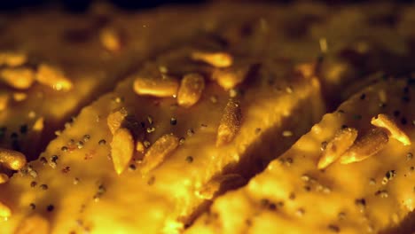 seeds being sprinkled over dough close up