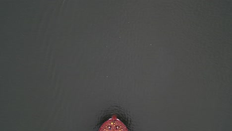 A-top-down-view-over-a-large,-red-container-ship-with-red-and-yellow-containers-on-the-Hudson-River-on-a-cloudy-day