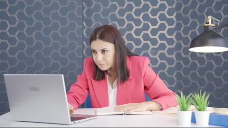 una joven mujer de negocios mirando la computadora portátil con emoción.