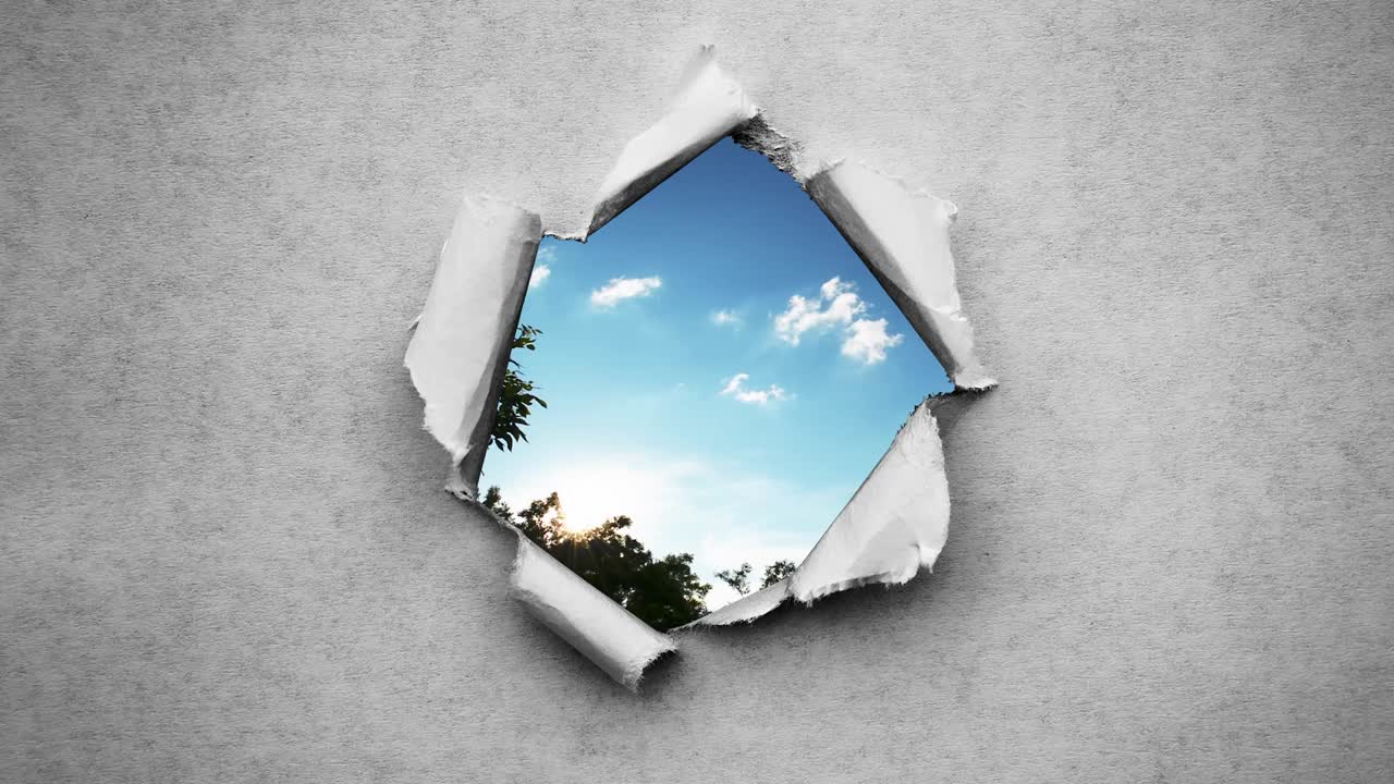 un video creativo de 4k de nubes en movimiento rápido en el cielo azul que son visibles a través de un agujero circular con bordes rasgados en viejo papel vintage retro grunge.
