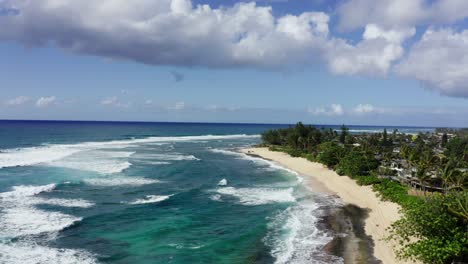 aerial view of tropical beach and coastline with waves and coastal homes