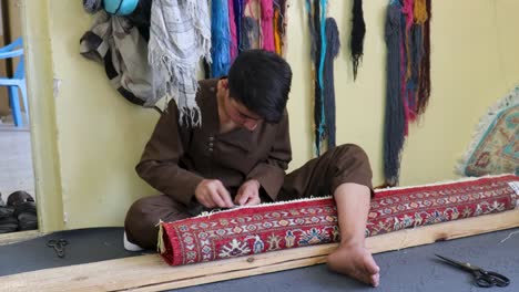 a young individual weaving rug selvages