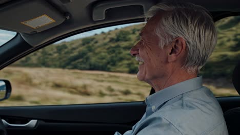 senior man driving classic car along winding countryside road, experiencing freedom and joy while enjoying scenic summer landscape during leisurely road trip