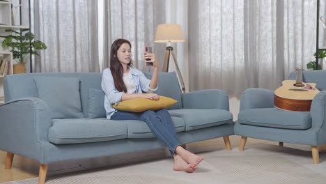 teenager having a video call on a couch at home